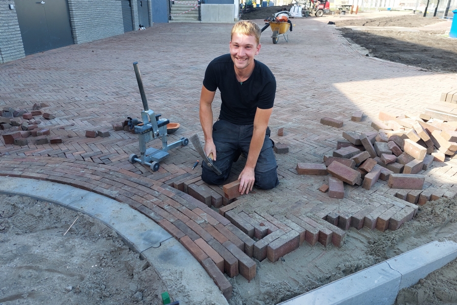 Emanuel Zwake legt de laatste hand aan de bestrating.